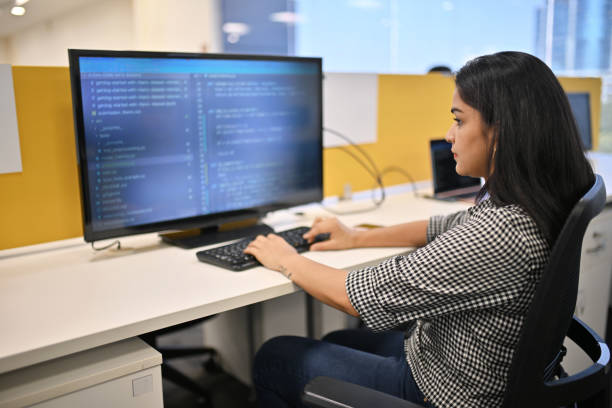 woman entering data sitting on a computer in an office